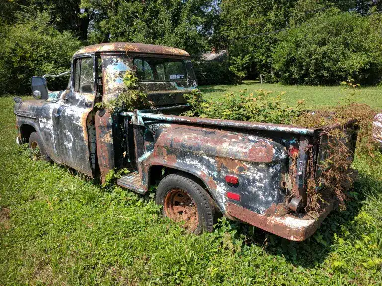 crusty old truck with weeds growing in the back like found in san antonio